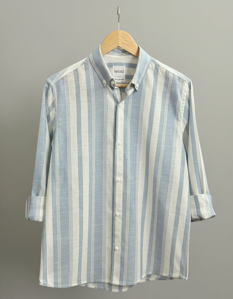 Striped shirt on a hanger against a neutral background