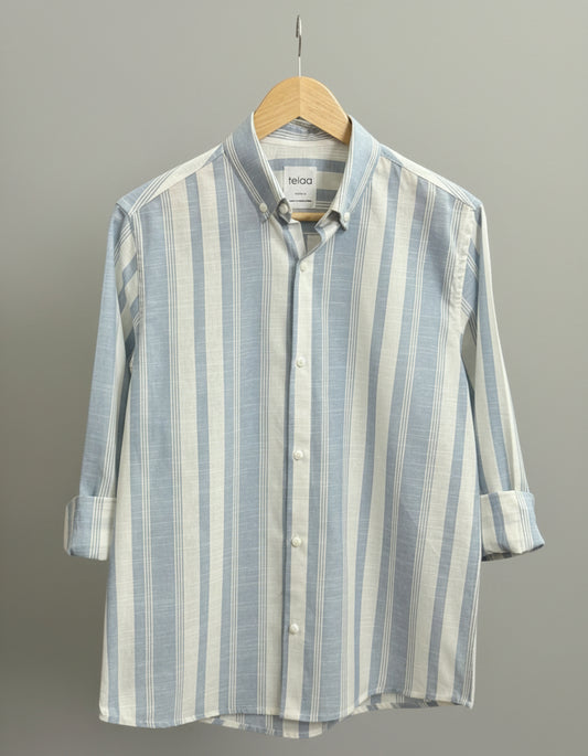 Striped shirt on a hanger against a neutral background