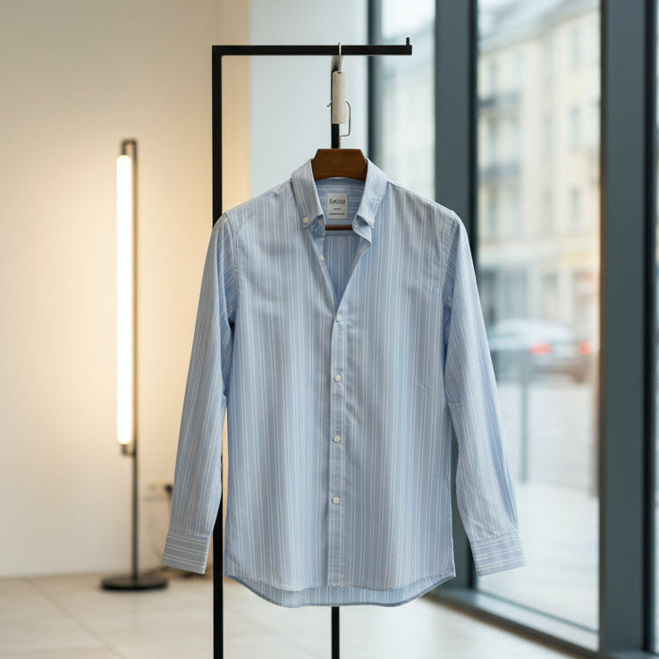 Blue striped shirt on a hanger in front of a window